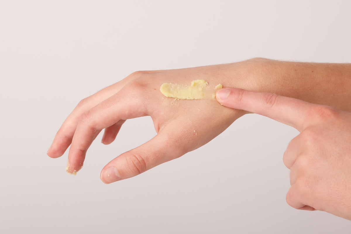 Solid tallow balm melting into the back of a hand
